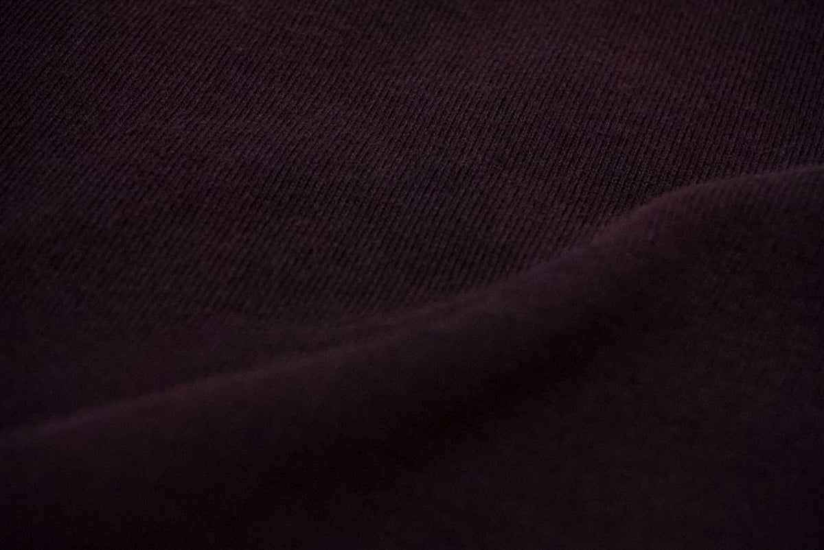 A close-up of black fabric with a fine woven texture and soft folds.
