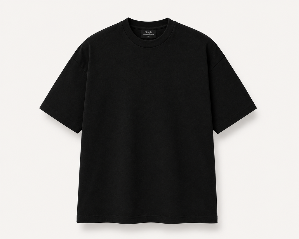 A black, slightly oversized, short-sleeve crewneck t-shirt laid flat against a light off-white background. A black woven label is visible inside the collar, reading 'Simple Luxury Goods'