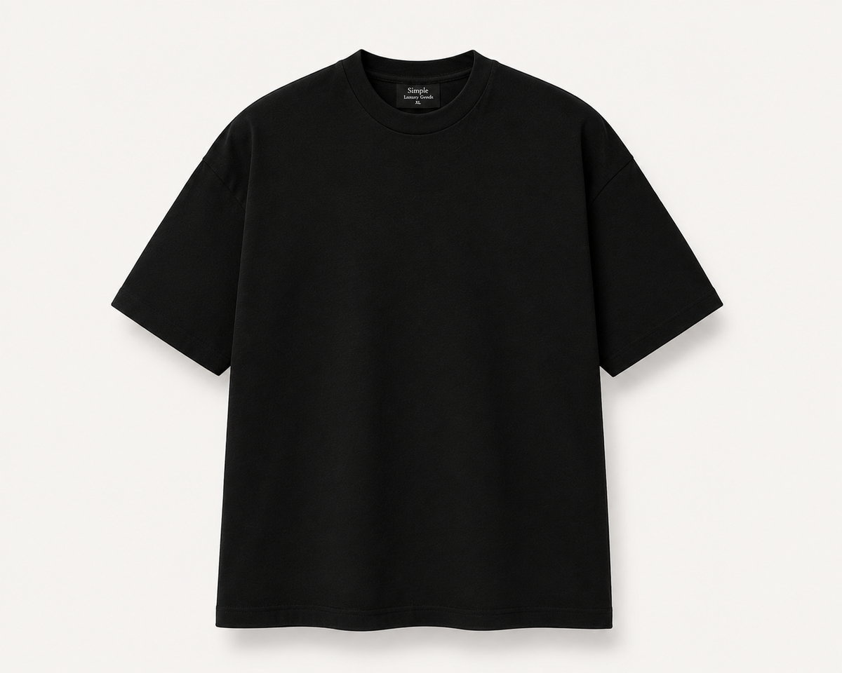 A black, slightly oversized, short-sleeve crewneck t-shirt laid flat against a light off-white background. A black woven label is visible inside the collar, reading 'Simple Luxury Goods'