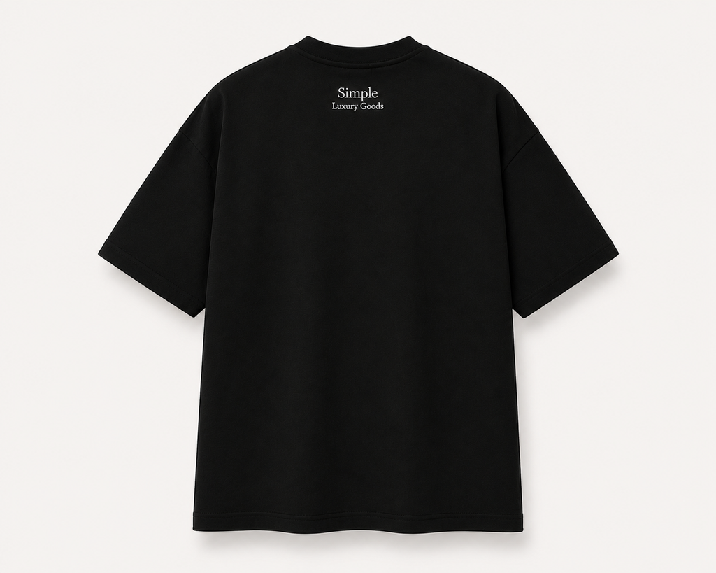 A black, slightly oversized, short-sleeve t-shirt shown from the back, featuring the text 'Simple Luxury Goods' embroidered in white at the center of the upper back, set against a light beige background.