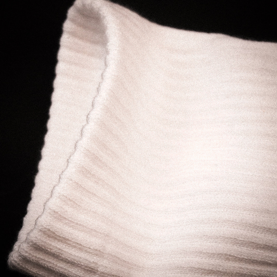 A close-up of a ribbed knit fabric cuff, shown against a solid black background.